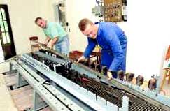 Mitglieder des Fördervereins für die Müglitztalbahn e.V. montieren die Schubstangen des Stellwerkes